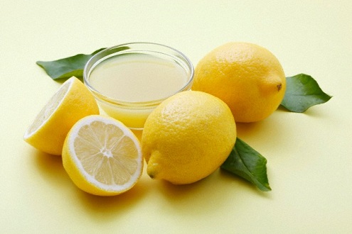 A bowl of lemon juice and fresh lemons